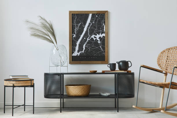 istock Modern scandinavian living room interior with mock up poster frame, design commode, leaf in vase, rattanarmchair, book and elegant accessories in stylish home decor. Template. 1278038043