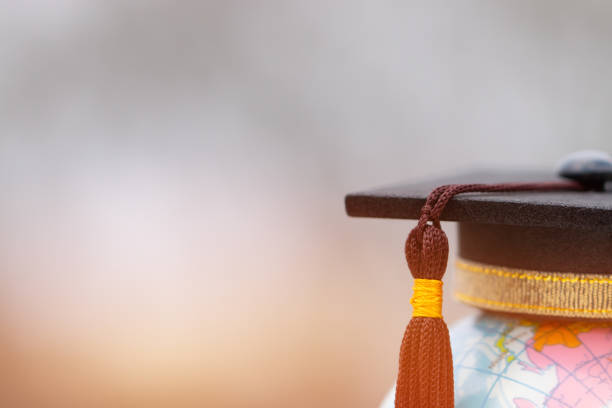 Graduate study abroad concept, Graduation cap on top Earth globe model map on laptop background. Graduate study abroad program, Back to School and Studies lead to success Graduate study abroad concept, Graduation cap on top Earth globe model map on laptop background. Graduate study abroad program, Back to School and Studies lead to success exchange student stock pictures, royalty-free photos & images