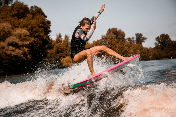 istock beautiful girl skillfully jumping over the wave on surf style wakeboard 1278040213