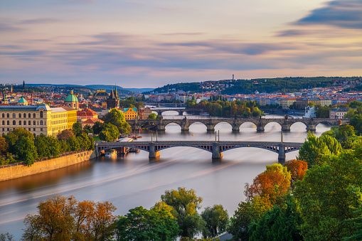 Vltava river with historic bridges of Prague at the golden hour photographed from Letna park. Long exposure.