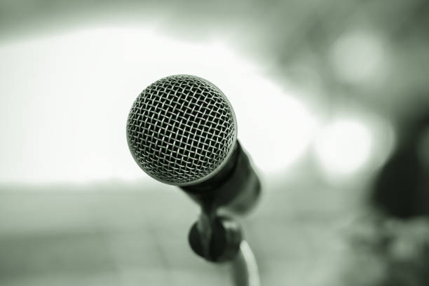 istock Microphone on abstract blurred of speech in seminar room or speaking conference hall light, Event Background 1278040737
