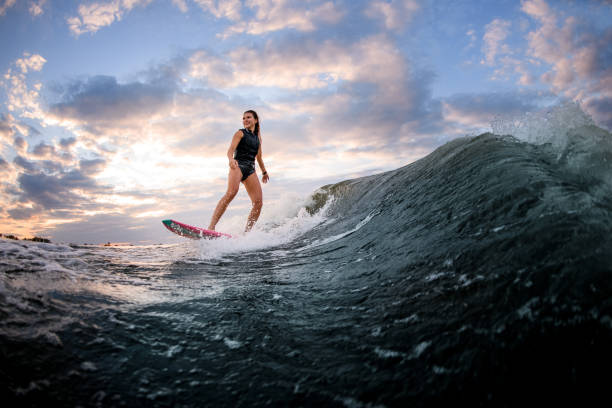 istock Young smiling woman riding down the wave on bright surf style wakeboard. 1278041897