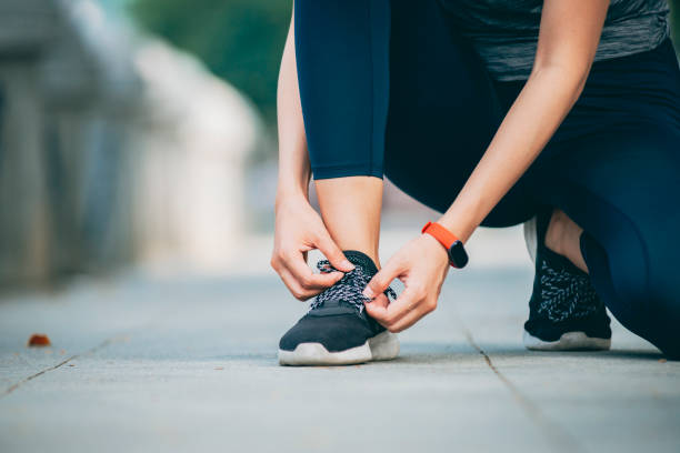istock Young woman tying athletic shoelace 1278044012