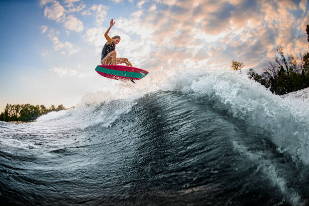 istock View on beautiful young woman skillfully jumping over big splashing wave on surf style wakeboard. 1278044015