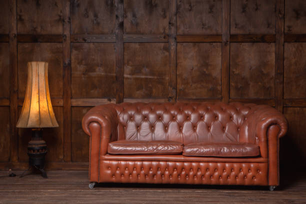 istock Classic brown loft style interior with wood paneling, chesterfield sofa. Old sofa on the background of vintage wall. High quality photo 1278045873