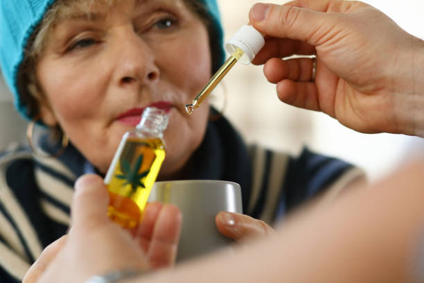 istock Sick elderly woman at home takes drops cannabis cup 1278050031