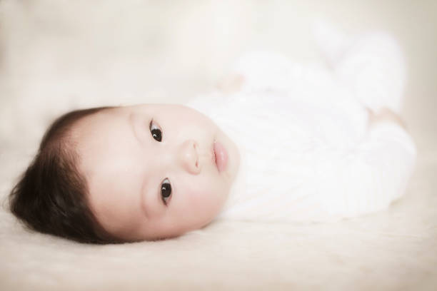 Cute baby lying in bed and looking up