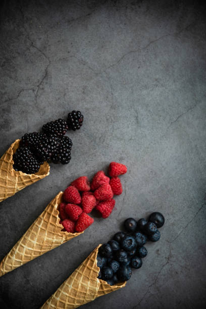 istock Fresh berries in waffle cones on dark stone background 1278051720