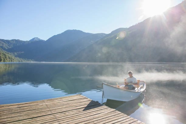 istock Man relaxes in rowboat, on tranquil lake 1278051758