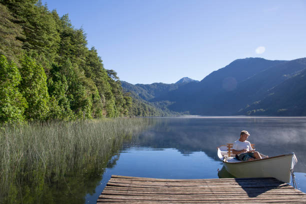 istock Man relaxes in rowboat, on tranquil lake 1278051995
