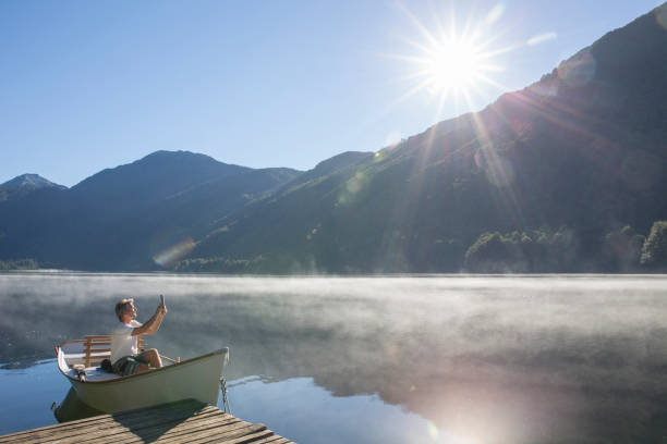 istock Man relaxes in rowboat, on tranquil lake 1278052273