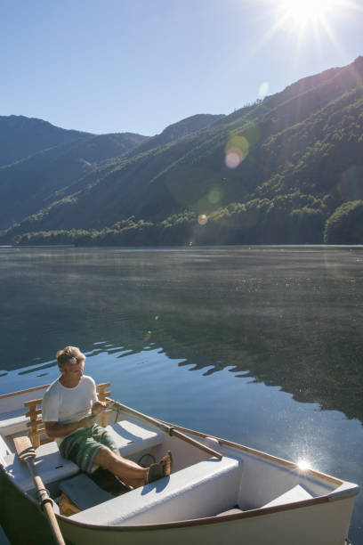 istock Man relaxes in rowboat, on tranquil lake 1278052276