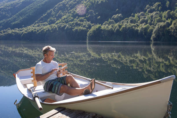 istock Man relaxes in rowboat, on tranquil lake 1278052456