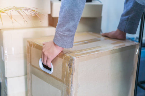istock Messenger or deliveryman holding parcel box package to deliver customer at home. Delivery service courier, Detail for delivery man carrying cardboard from Online shipping  courier 1278053902