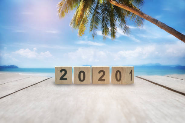 istock Wooden cube 2020 to 2021 on plank on tropical beach background 1278056616
