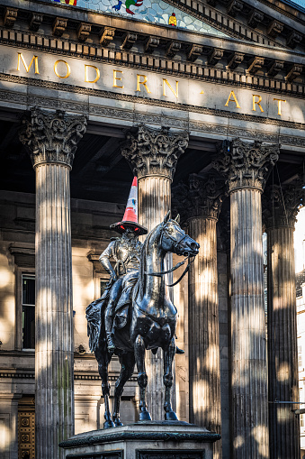 Glasgow, Scotland - The Glasgow tradition of putting a traffic cone on the head of the Duke of Wellington's statue in front of the GOMA - the Gallery of Modern Art, located in the city centre.