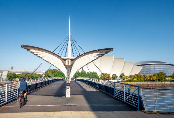 Belll's Bridge over the Cylde in Glasgow Glasgow, Scotland - Cyclists and pedestrians crossing the river Clyde, with The Armadillo and The Hydro of the SEC to the right. clyde river stock pictures, royalty-free photos & images