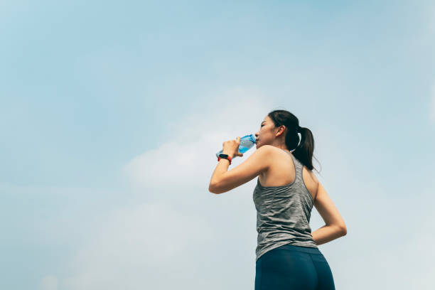 istock Young woman drinking water after exercising 1278059514