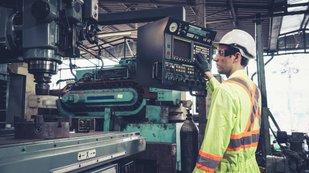 intelligenter fabrikarbeiter mit maschine in der fabrikwerkstatt - industriegerät stock-fotos und bilder