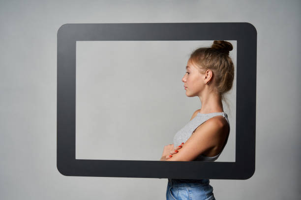 istock Profile of girl standing behind digital tablet frame and looking forward at blank copy space 1278061458