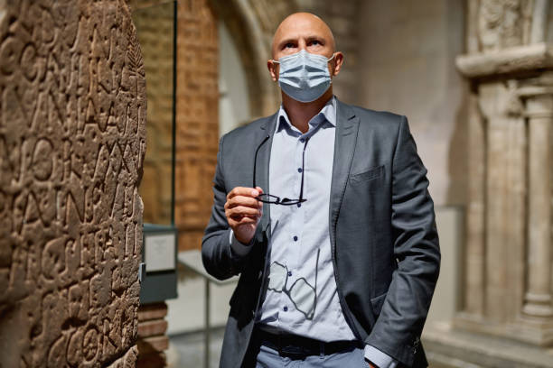 istock Man looking at museum exhibition in an antivirus mask 1278063803