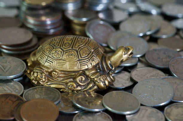 istock A metal turtle next to a stack of coins. 1278064982