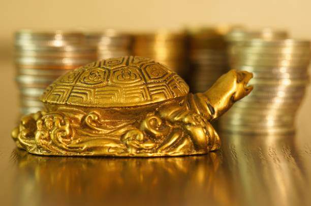 istock A metal turtle next to a stack of coins. 1278065011