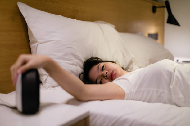 joven hermosa mujer asiática odia despertarse temprano en la mañana - sleeping insomnia alarm clock clock fotografías e imágenes de stock