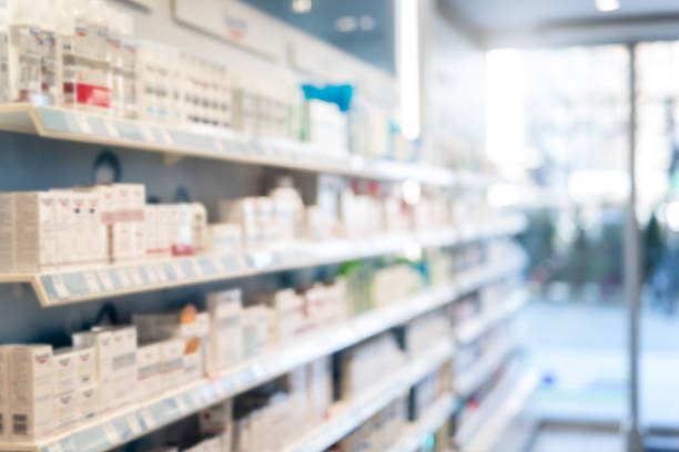 Blurred Pharmacy Background. Photo of blurred Pharmacy. Medical product shelves and entry doors. pharmacy photos stock pictures, royalty-free photos & images