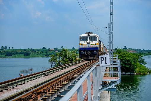 Pune, India - October 02 2020: Diesel locomotive hauling a passenger train over a bridge near Pune India.
