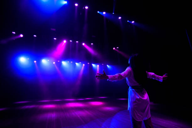 istock Unrecognizable singer standing on stage at microphone, back view, neon lights 1278077753