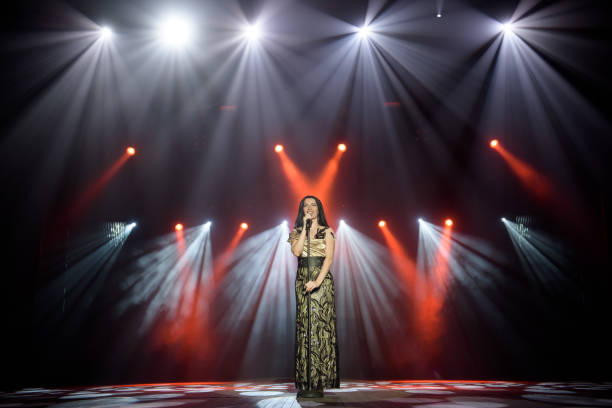 istock Young woman with microphone in hand on entertainment event. 1278077763