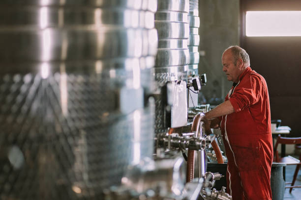 istock Employee takes a sample from a stainless steel fermentation tanks 1278084480