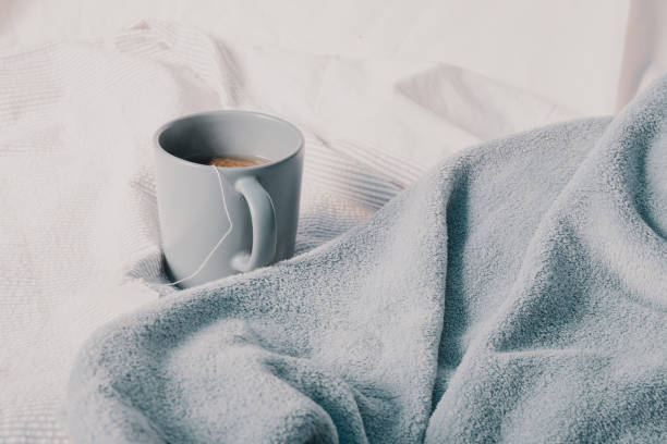 istock Chamomile tea on the bed. Cozy autumn home background. 1278084543