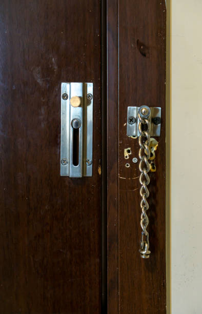 istock Door chain attached to a brown door as a security measures 1278084633