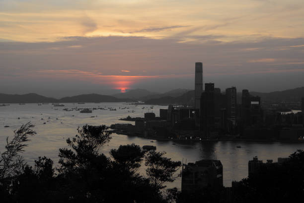 Sunset in Hong Kong Hong Kong ICC skyscraper and Kowloon peninsula at dusk, viewed from Braemar Hill, a mountain on the Hong Kong Island in Hong Kong. international commerce center stock pictures, royalty-free photos & images