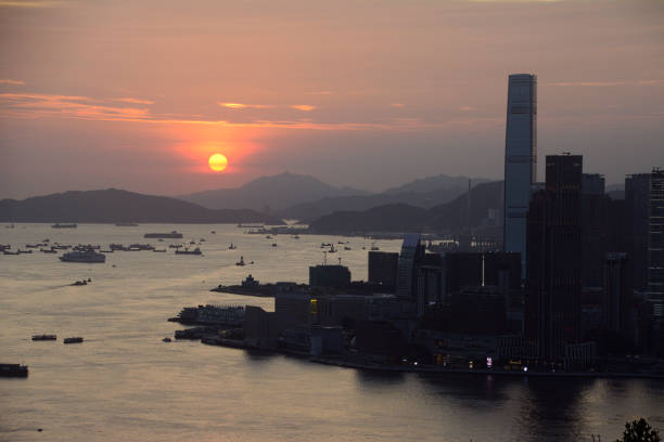 Sunset in Hong Kong Hong Kong ICC skyscraper and Kowloon peninsula at dusk, viewed from Braemar Hill, a mountain on the Hong Kong Island in Hong Kong. international commerce center stock pictures, royalty-free photos & images