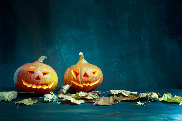 istock Halloween. Image featuring two pumpkins with burning candles and lightning 1278096508