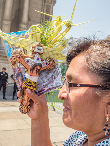 Lima, Peru - March 29, 2018: Peruvian woman showing  an Easter palm on   the street of Lima before Easter time. Maundy Thursday.   Plaza de Armas, Peru, South America. Latin America