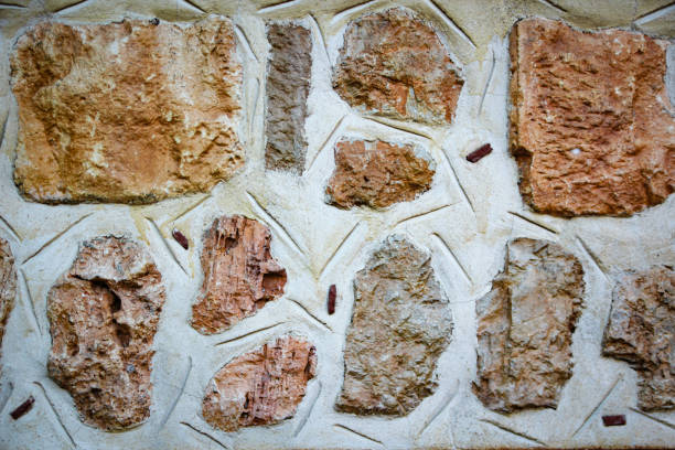 background of the building wall made of stones with white plaster