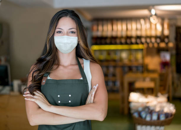 istock Woman working at a supermarket wearing a facemask 1278100841