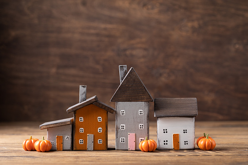 Miniature Thanksgiving Day little cosy fairy tale autumn cottages, pumpkins, wooden background, postcard concept, toned
