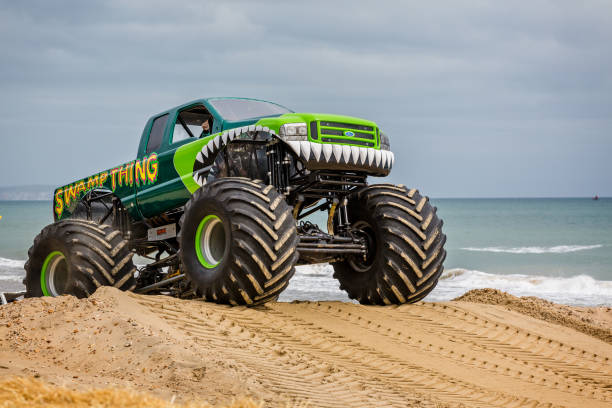 монстр грузовик на пляже, принятых в борнмуте, дорсет, великобритания - british racing green стоковые фото и изображения