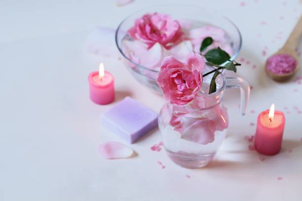 istock Fresh pink roses, water, petals, candles on a light background 1278106807