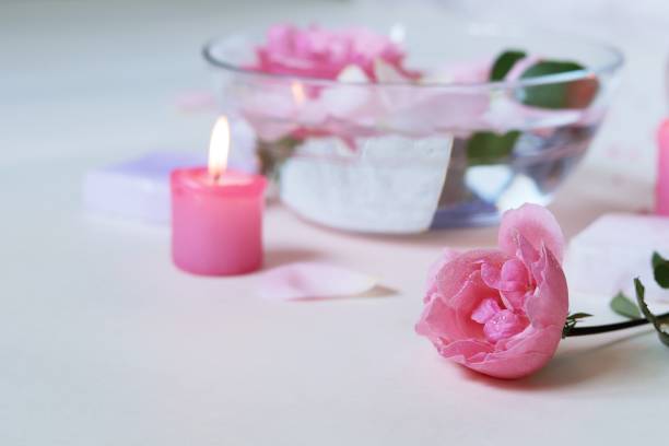 istock Fresh pink roses, water, petals, candles on a light background 1278106844