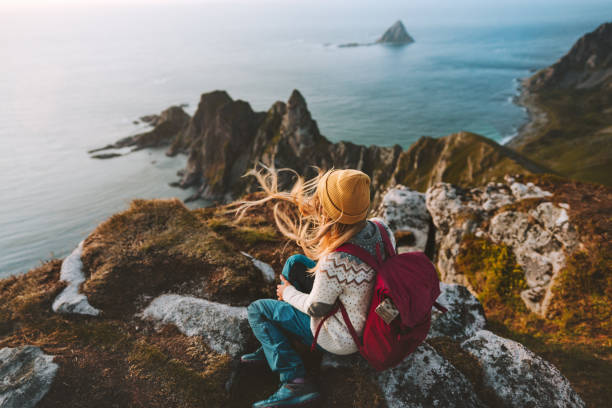 ノルウェーの冒険で一人旅をリラックスしている女性は、美しいライフスタイルをバックッキングヴェステラレン風景の岩と海の空中写真 - hair pace ストックフォトと画像