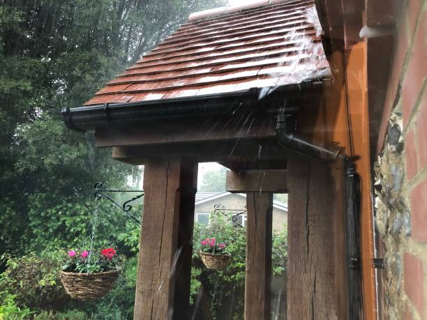 istock Heavy rain rushing down the porch roof 1278110706