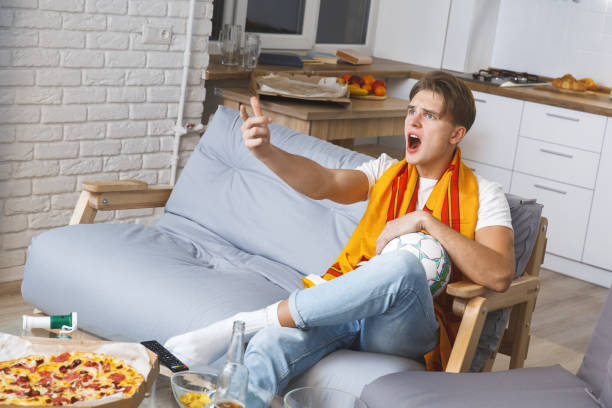 człowiek oglądania sportu w telewizji w domu sam nieszczęśliwy - sitting 20s adult american football zdjęcia i obrazy z banku zdjęć