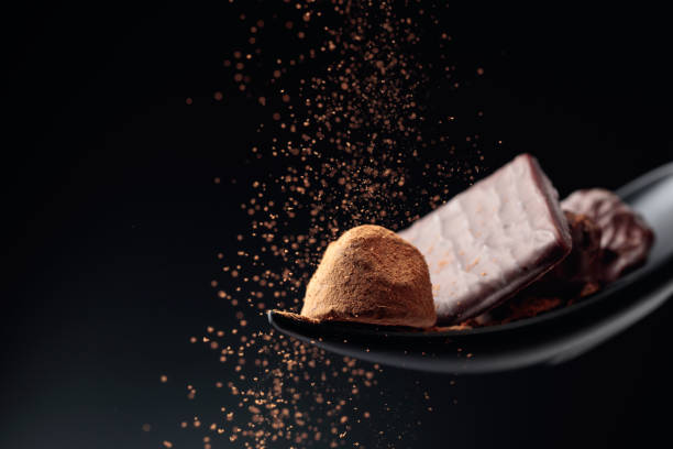 istock Chocolate candy sprinkled with cocoa powder on a dark background. 1278113416