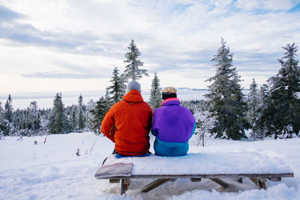 istock Young couple sitting down enjoying the winter landscape view 1278113614